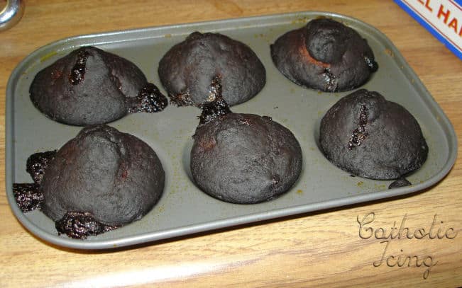 Misshapen chocolate cupcakes in a muffin pan.