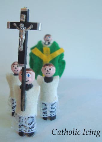 Three altar server peg dolls with priest peg doll in the background. 