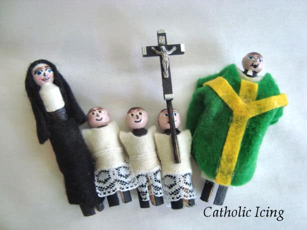 Five catholic peg dolls, one nun, three altar servers, and one priest on a white background. 